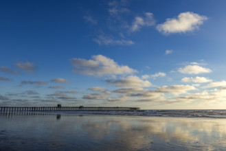 Oceanside Pier and calm ocean in late afternoon. Oceanside, California, USA.