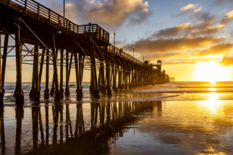 Oceanside Pier and calm ocean at sunset. Oceanside, California, USA.