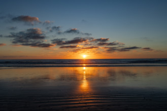Sun setting over calm ocean. Oceanside, California, USA.