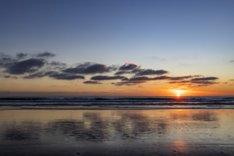 Sun setting over calm ocean. Oceanside, California, USA.