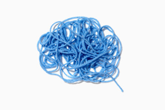 Tangled blue yarn on white background. New York City, New York State, USA.