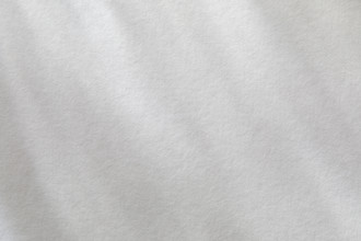 Dappled light on textured white paper. New York City, New York State, USA.