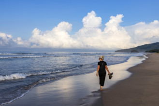 Rear view of woman walking on beach at dawn, Playa Grande, Guanacaste, Costa Rica.