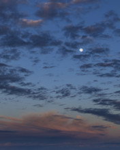 Moon rising on cloudy sky, Kettleman City, California, USA.