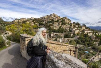 Smiling senior woman looking at old town, Gordes, Vaucluse, France.