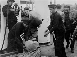 Marins déchargeant des sacs postaux d’un transbordeur, à Queenstown
