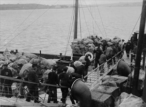 Marins chargeant des sacs postaux à bord du transbordeur "Flying Fish"