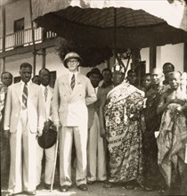 Empire Day in Aburi, 1950. A European colonial officer stands beneath a shady parasol with an Agona