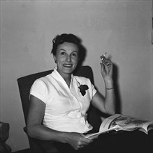 Mrs Douthwaite smoking. Mrs Douthwaite enjoying a cigarette whilst reading a magazine. Kenya, 21