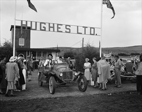 Hughes Ltd. Hughes Ltd at the Royal Show. A cheerful group surrounds a man in a vintage car.
