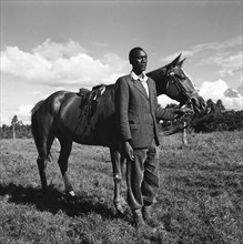 Fosdick's horses. Atmospheric photograph of an African man standing with one of Fosdick's horses at