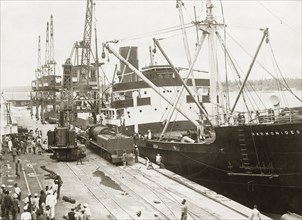 A train unloaded from SS Harmonides. A locomotive boiler and tender have been lowered onto a bogie