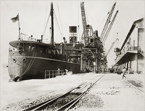 Loading grain on SS Modasa. SS Modasa docked at Kilindini harbour. Mombasa, Kenya, circa 1930.