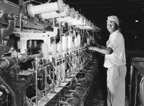 Spinning bobbins. A factory worker spins sisal fibre onto bobbins at Sisal Products Ltd. Grown
