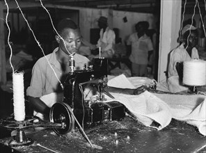 Factory worker sewing. A factory worker operates an industrial sewing machine at Sisal Products Ltd
