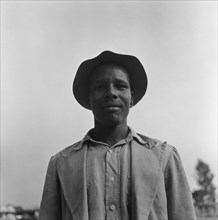 Man at a cleansing ceremony. Upper body shot of a man wearing a checked shirt, jacket and hat taken