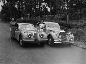 Wives and Jaguars. Two women with their husbands' cars: Peter Knight's Jaguar Coupe (left) and