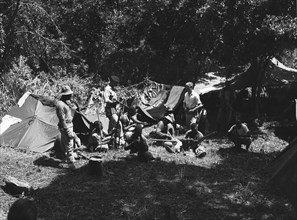 KAR bivouac. A mixed race group of soldiers in the King's African Rifles (KAR) check and clean