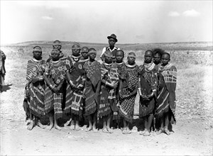 Barabaig chief with young women. A chief from the Barabaig tribe stands over a group of young