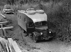 Stuck in the mud. An old-fashioned caravan is stuck on an uneven dirt path. The vehicle's
