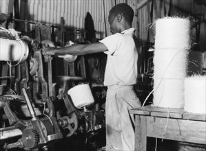 Spinning twine. A factory worker spins sisal fibre into twine at Sisal Products Ltd. Grown