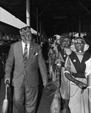 Jomo Kenyatta with his female bodyguard. Jomo Kenyatta, new leader of independent Kenya, walks