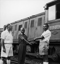 Railway workers shake hands. A publicity photograph from the East African Railways and Harbours