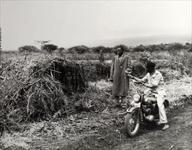 Agricultural officer. A uniformed agricultural instructor offers advice to an African farmer as he