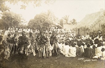 A traditional Fijian 'meke'. A crowd watches as a group of male Fijian dancers dressed in