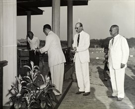 Opening the new club house. The Burmese President of the Rangoon Golf Club cuts a ribbon to declare