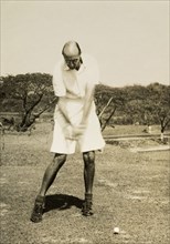 Stiff left side'. R.B. Groves, a Captain of the Rangoon Golf Club, takes a swing at the ball on the