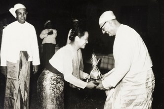 Receiving a 'Na-Ya' award. A European employer, dressed in a traditional Burmese 'longyi', is