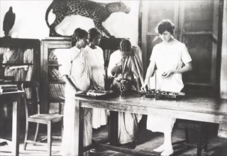 Botany lesson at a Women's Christian College. Four female students (three Indian and one European)