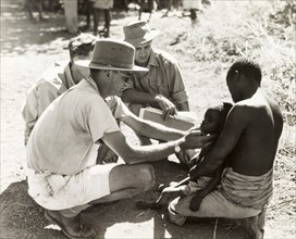 Doctor examining a child with sleeping sickness. A European medic, identified as Dr Cookson, is
