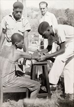 An African medic injects a patient. An African medic gives an injection to a female patient, while