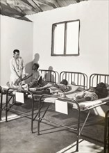 A European doctor examines African patients. A European doctor examines a patient as he sits on a