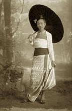 Portrait of a Burmese lady. A studio portrait of a young Burmese woman, elegantly posed with a