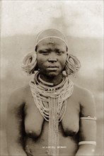 Kikuyu woman. Half-length portrait of a semi-naked Kikuyu woman wearing neck chains and heavy