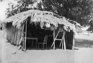 Thatched classroom. A three-walled classroom constructed from wooden poles and a thatched roof.