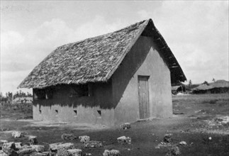 New classroom. A completed timber-frame and plaster classroom, with thatched roof, erected by the