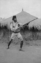 Askari from Second King's African Rifles. An African askari (soldier) poses with his gun in front