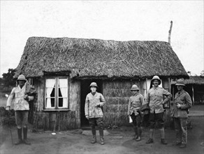 Thatched cottage in the Transvaal. Five European men in army uniform outside a small cottage: