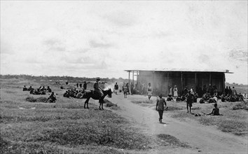 African market at Nairobi. People at an African market being held near a track in open grassland.