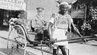 Rickshaw puller in Durban. An African rickshaw puller wearing a horned headdress and a decorated