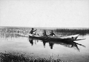 Canoe on Lake Victoria. Three men paddle a canoe through the shallows of the lake. Lake Victoria,