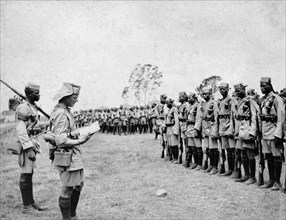 King's African Rifles depart for war. A European officer reads instructions to a line of African