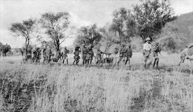Machine-gun section of the King's African Rifles on trek. A European officer leads a line of