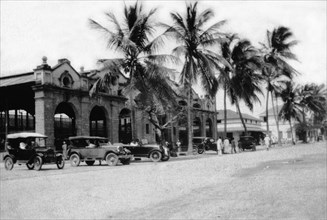 Mackinnon Market at Mombasa. Cars and palm trees line Digo Road in front of Mombasa's municipal
