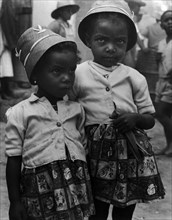 Grenadian schoolgirls. Two small Grenadian schoolgirls stand close together dressed in matching