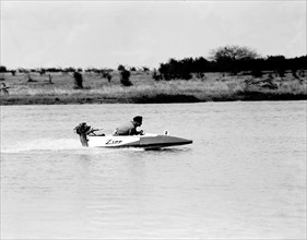 Zipping' along. Ron Richardson scuds across a lake in a small 'Zipp' speedboat during a race at the